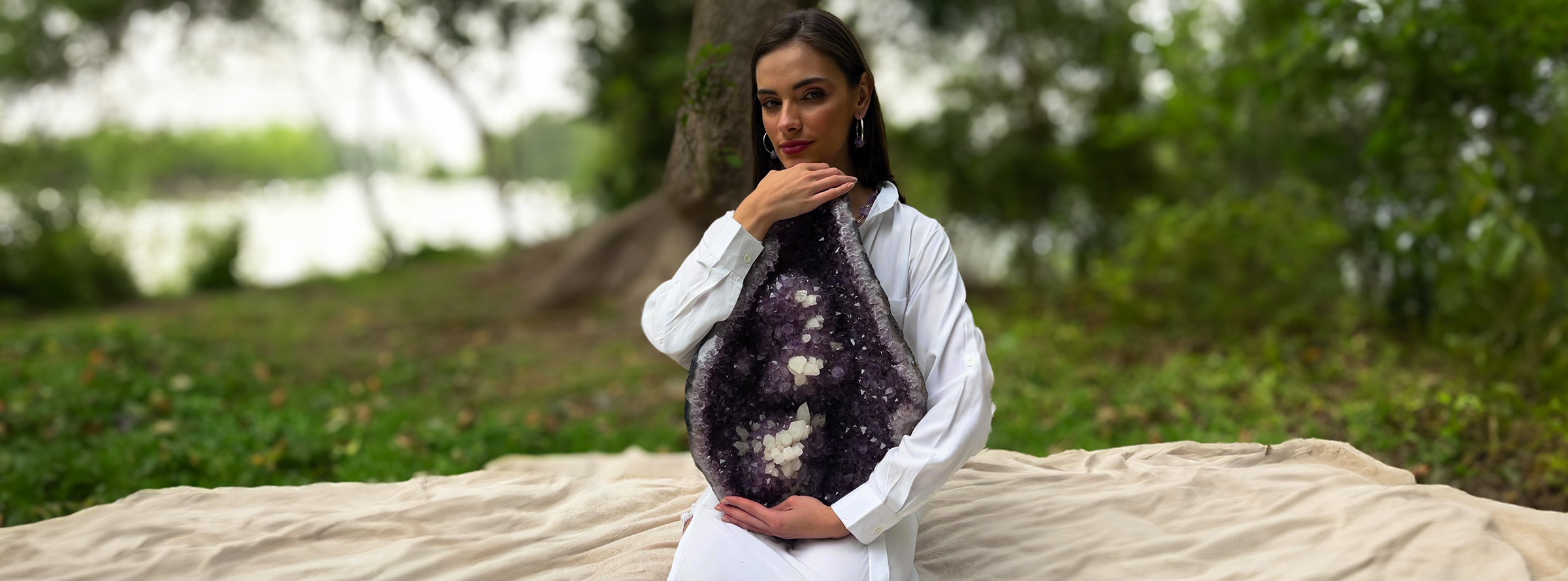 Mujer con una drusa amatista entre las manos en la naturaleza