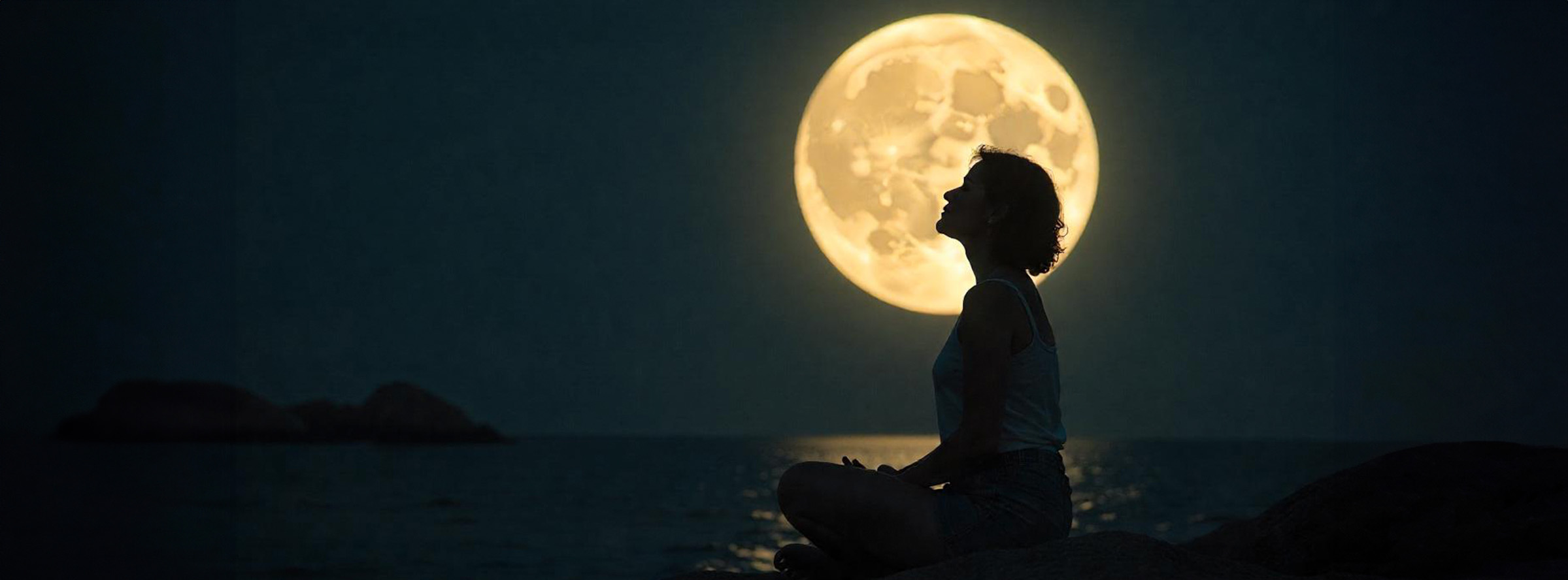 Mujer meditando en la orilla del mar de noche de luna llena